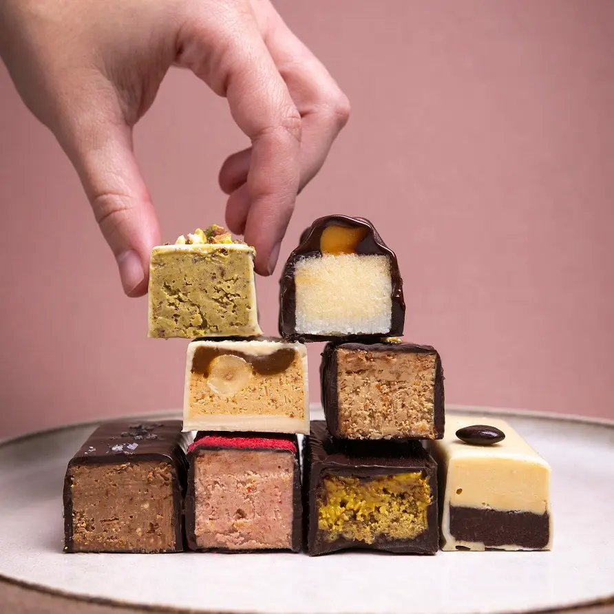 Dulces artesanos de chocolate apilados en obrador de pastelería creativa en Barcelona